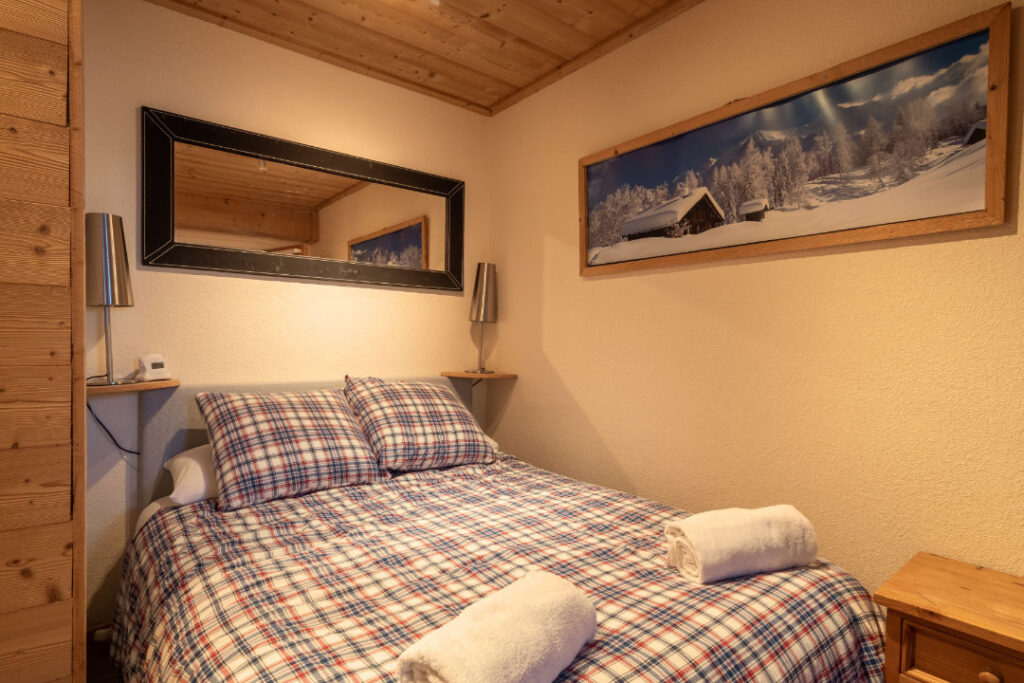 Interior view of Bedroom 5 in Chalet Aventure, featuring a double bed and ensuite shower room.