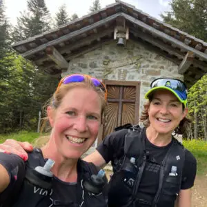 Two women celebrate after trail running to the summit of the Chapelle de Jacquicourt trail in Les Gets.