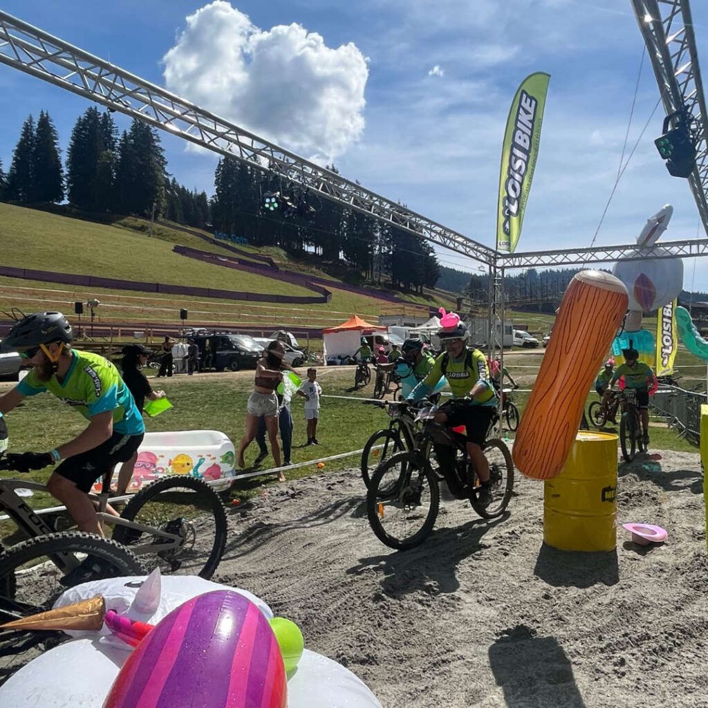 Participants cycling during the 24 Hours Alambike event in Les Gets, surrounded by scenic mountain views.