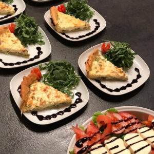 Freshly baked tomato quiche with a flaky crust, served on a rustic wooden board for a great meal in Les Gets
