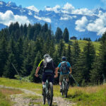 Mountain bikers riding downhill in the scenic trails of Les Gets during summer