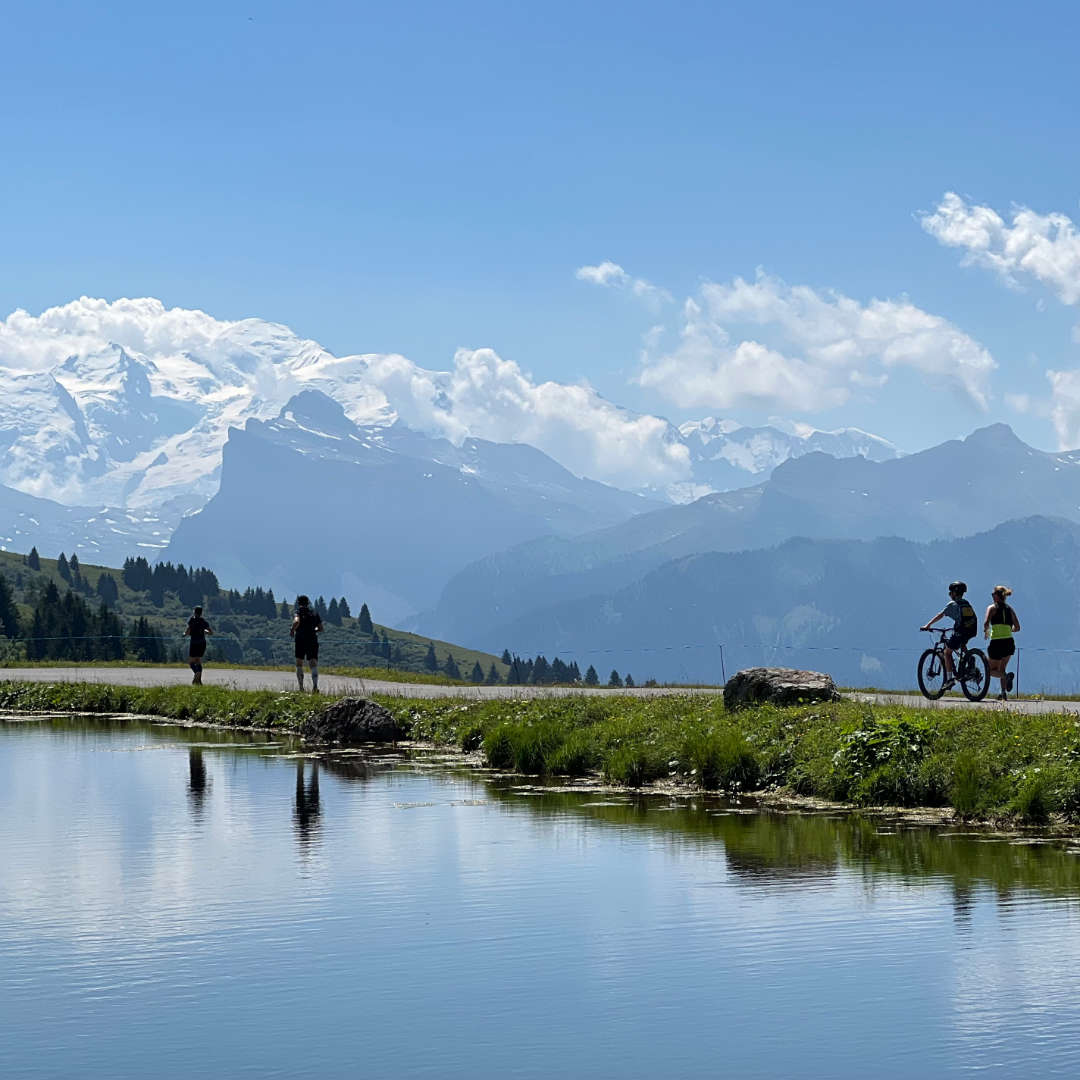 Mountain biker and trail runner with Mont Blanc in the background during an outdoor adventure