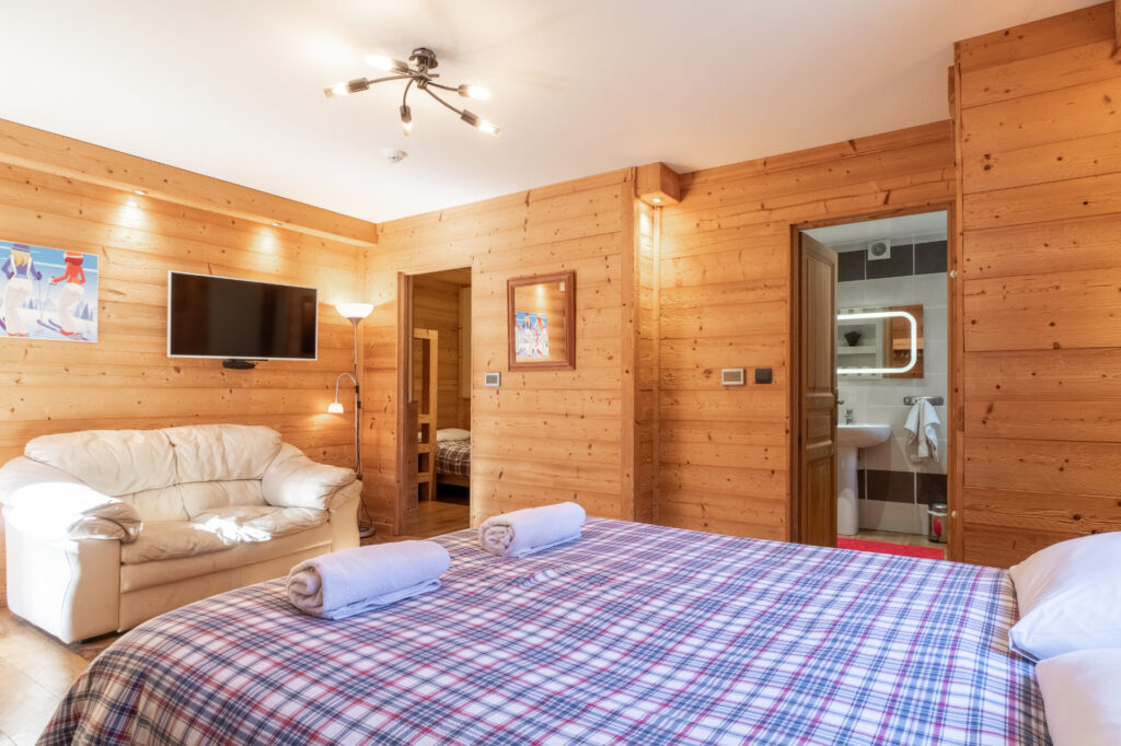 Interior of Bedroom 4 Perrieres at Chalet Aventure, featuring a double bed and a side room with a bunk bed and a single bed, suitable for up to 5 guests.