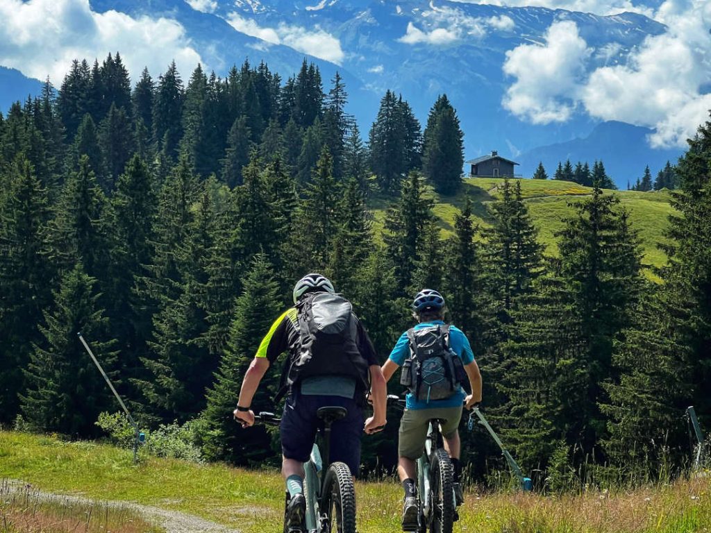 Mountain bikers riding downhill in the scenic trails of Les Gets during summer